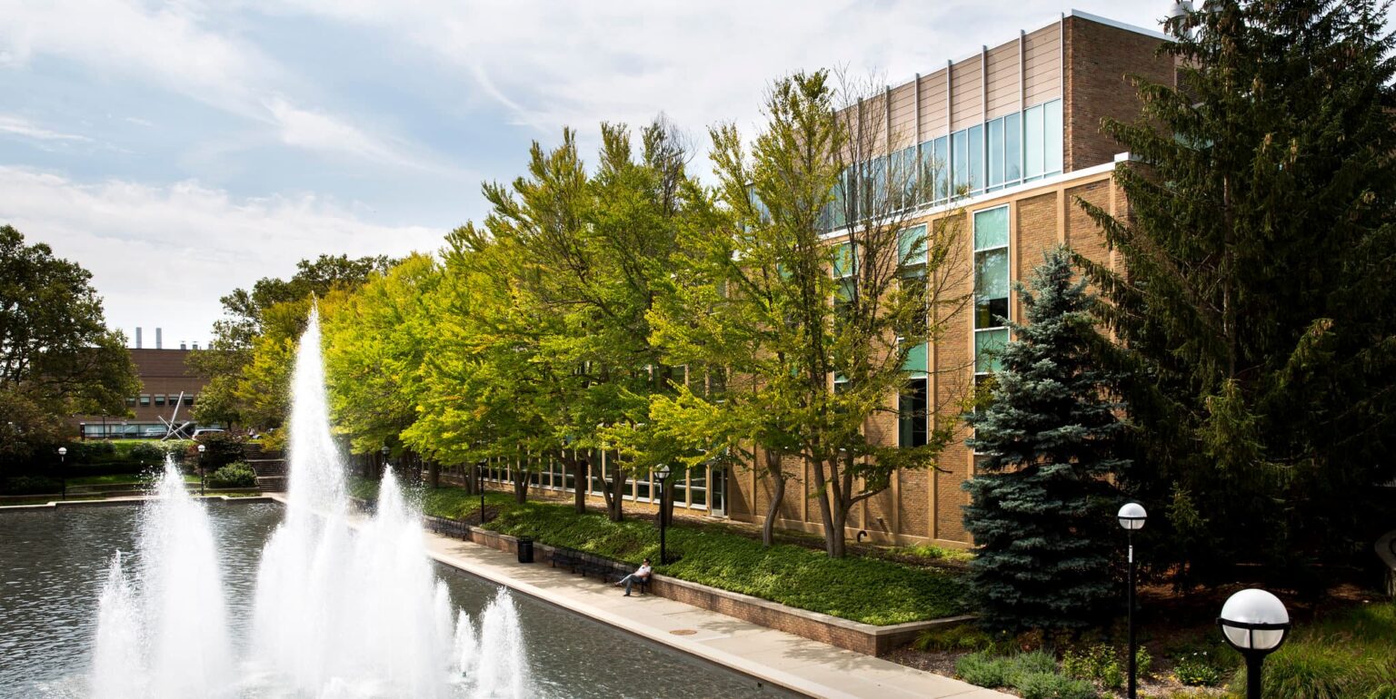 brick building exterior with trees and fountain