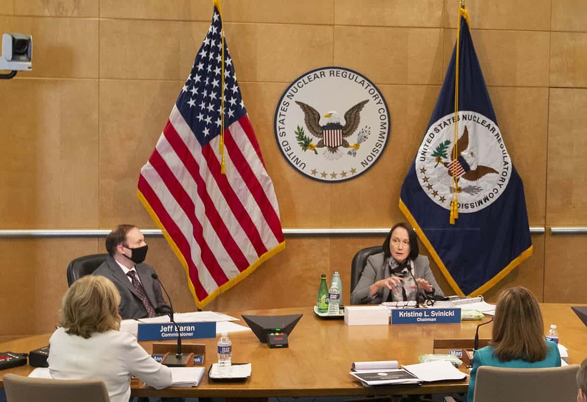 a woman speaking at a board meeting