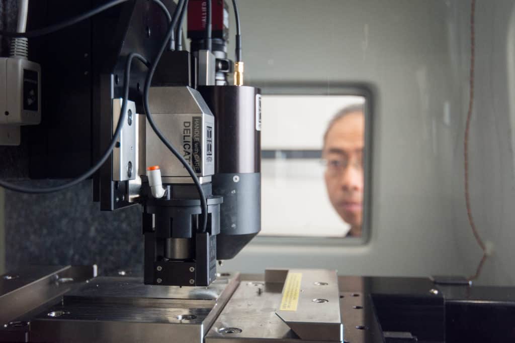 man looking through a window at machinery