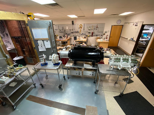 a black tank surrounded by carts in a laboratory