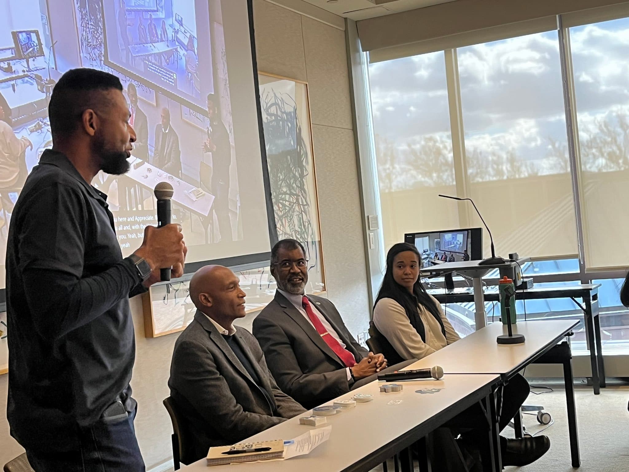 a group of people speak on a panel