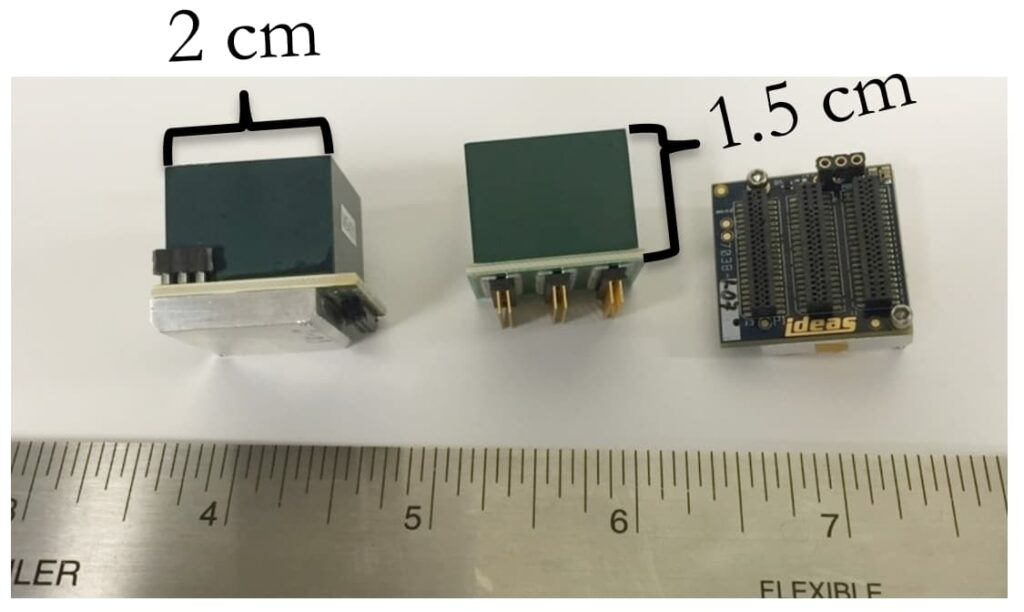 Three small mechanical devices and a ruler showing that one device is 2cm and another is 1.5cm