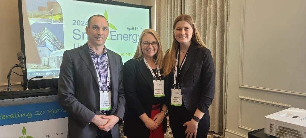 three people posing at a conference