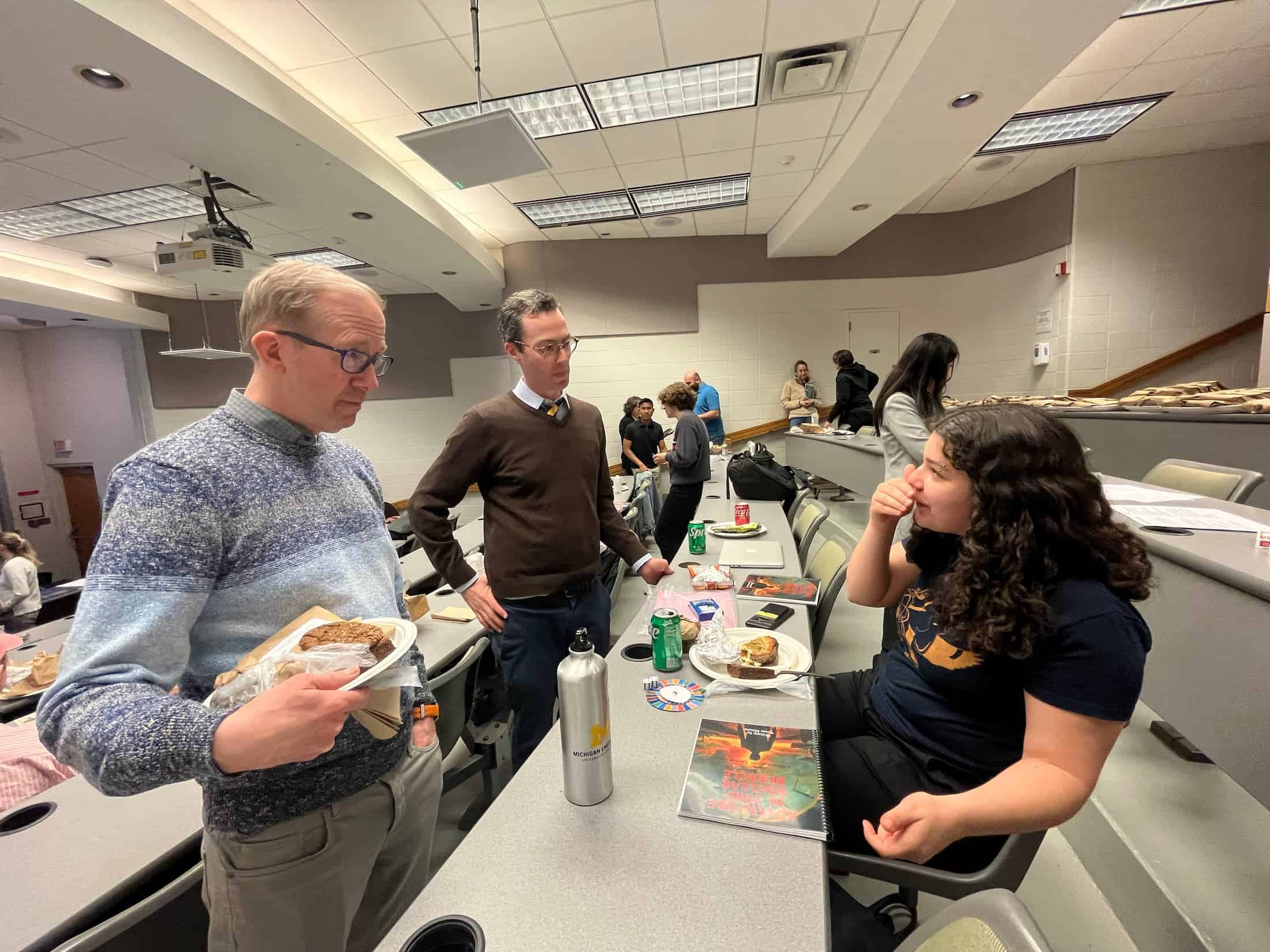 a student explains their project to two professors